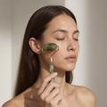 Jade roller being drawn upward along the cheekbone
